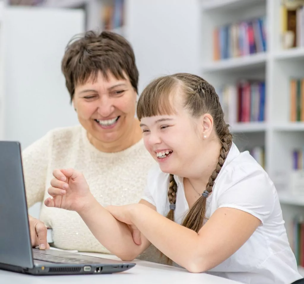 Smiling,Girl,With,Down,Syndrome,Is,Uses,A,Laptop,With